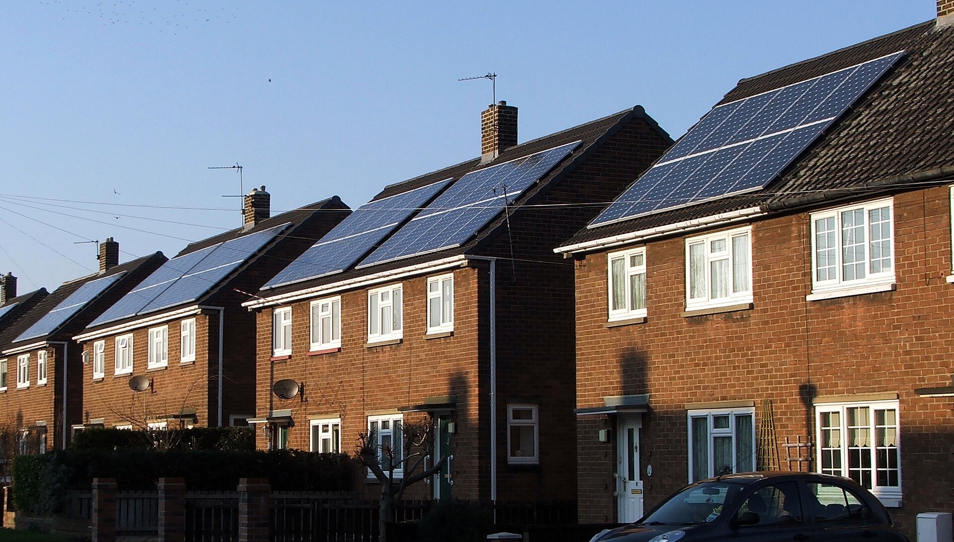 Illustrative UK brick homes with rooftop solar panels.